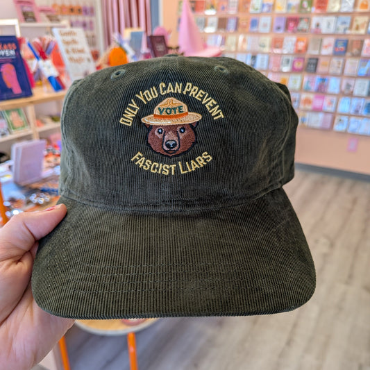 Olive green Ghost Poppy Only You Corduroy Hat featuring an embroidered bear in a VOTE park ranger hat with the text ONLY YOU CAN PREVENT FASCIST LIARS.