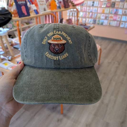 Ghost Poppy Only You Dad Hat in olive green, featuring an embroidered bear in a park ranger hat with the text ONLY YOU CAN PREVENT FASCIST LIARS and VOTE.