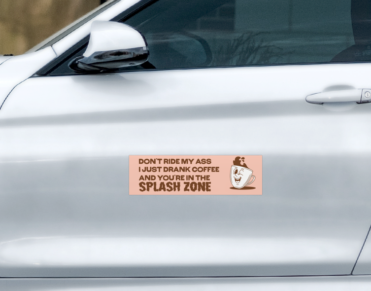 Rectangular, heavy-duty Splash Zone Car Magnet on a car door reading Don’t ride my ass, I just drank coffee and you’re in the splash zone, featuring a cartoon winking coffee mug.