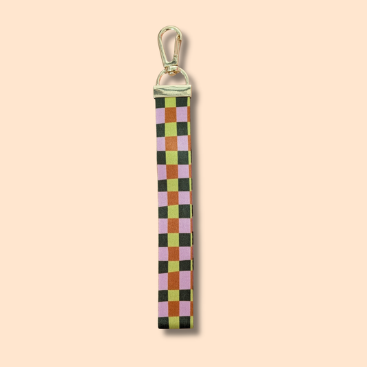 Elevate your fall style with the Ghost Poppy Fall Plaid Wristlet Lanyard Keychain—a chic wristlet featuring a gold clasp and a classic plaid pattern in green, pink, yellow, and brown on a light beige background. This stylish accessory is perfect for autumn!.