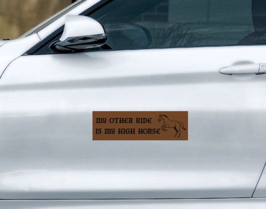A rectangular, weatherproof brown My High Horse Car Magnet on a silver car door, featuring a silhouette of a horse and the text MY OTHER RIDE IS MY HIGH HORSE.