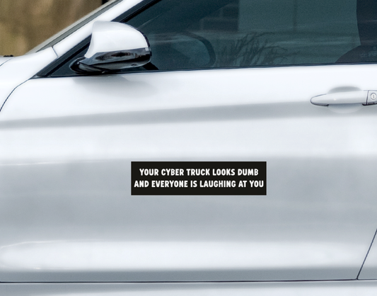 A You Look Dumb Car Magnet on a silver vehicle door that reads, YOUR CYBER TRUCK LOOKS DUMB AND EVERYONE IS LAUGHING AT YOU.
