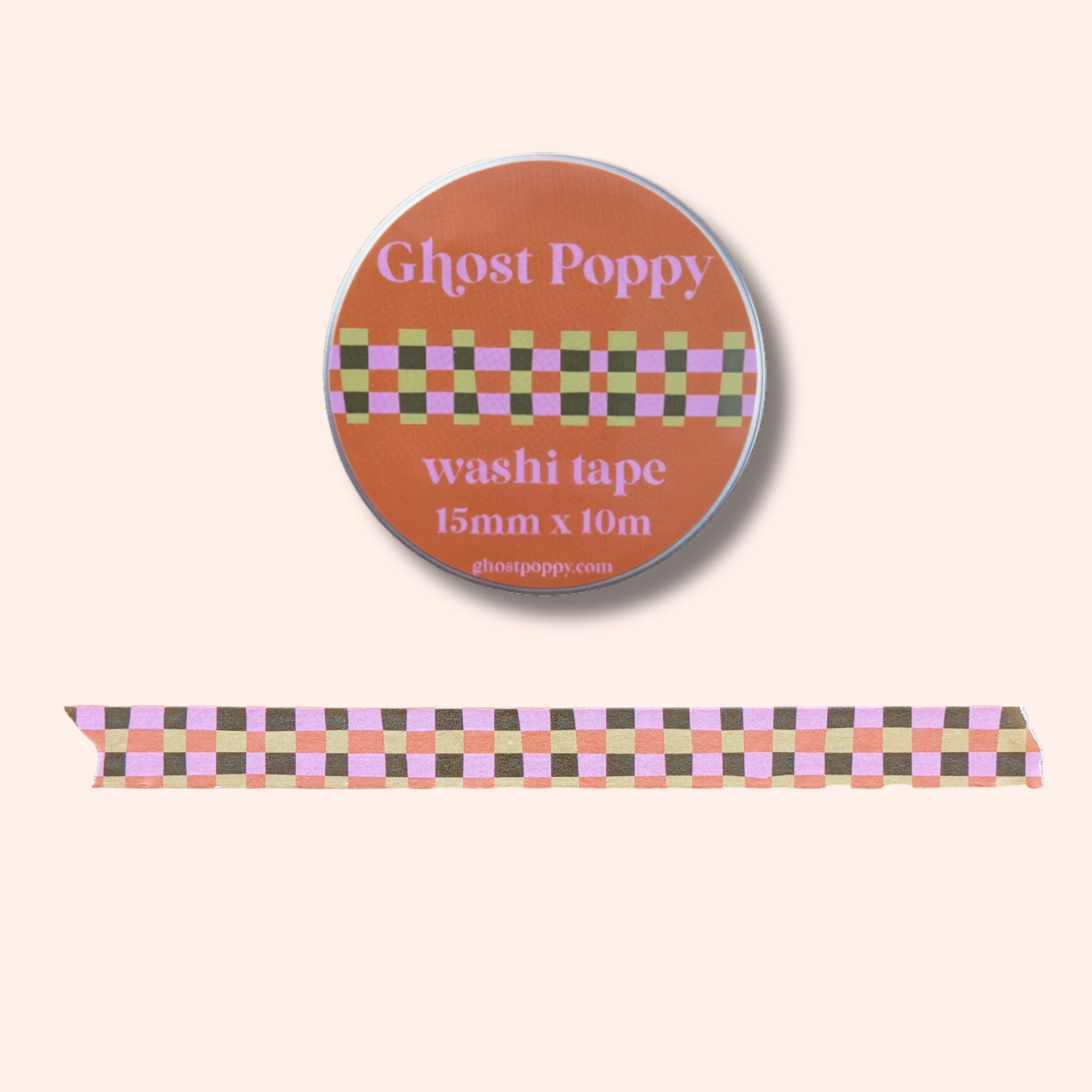 Round orange washi tape roll labeled Ghost Poppy, featuring a plaid pattern in pink, brown, and yellow. This Fall Plaid Washi Tape is shown with a matching strip of patterned rice paper tape below—perfect for adding a unique touch to your scrapbooking projects.
